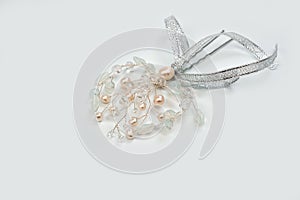 A hair clip on a hairpin in the form of a twig made of silver wire, decorated with river pearls and crystal