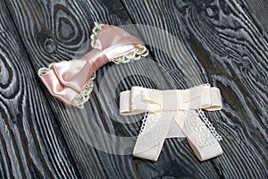 Hair clip made of pink ribbon. On pine boards painted black and white