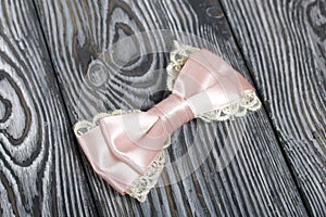 Hair clip made of pink ribbon. On pine boards painted black and white