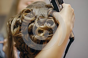 Hair curlers make curls on women`s hair. Services of a hairdresser for evening and festive hairstyles concept