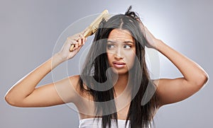 Hair, damage and woman with brush in studio with worry for knots, haircare crisis and weak texture. Beauty, hairdresser