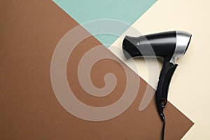 Hair dryer on color background, space for text. Professional hairdresser tool