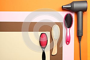 Hair dryer and different brushes on colr background. Professional hairdresser tool