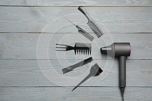 Hair dryer and professional hairdresser tools on wooden table