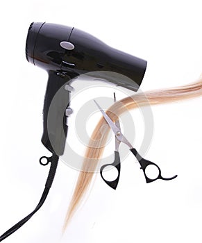 Hair dryer, scissors and lock of hair isolated on