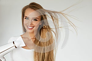 Hair Dryer. Woman Drying Beautiful Blonde Long Straight Hair