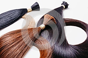 Hair extensions of three colors on a white background. copyspace selective focus photo