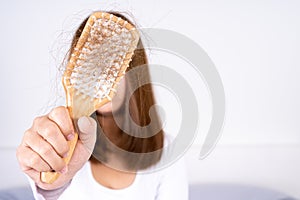 Hair fall problem, closeup hand holding comb and problem hair. Healthcare medical or daily life concept