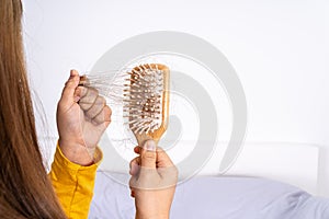 Hair fall problem, closeup hand holding comb and problem hair. Healthcare medical or daily life concept