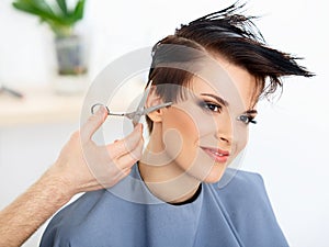 Hair. Hairdresser Cutting Woman's Hair in Beauty Salon. Haircut