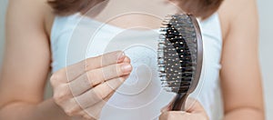 Hair loss problem, Balding , Beauty treatments and health care concepts asian woman holding holding comb with hair loss, young