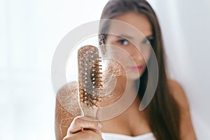 Hair Loss. Upset Woman Holding Brush With Hair photo