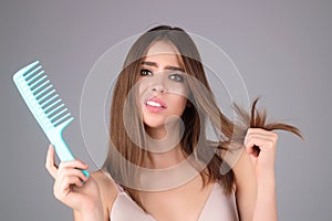 Hair loss woman with a comb and problem hair. Hairloss and hairs problems. Sad girl with damaged hair. Tangling hairs