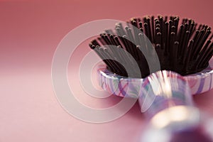 Hair massage comb brush with handle for all types  on pink pastel copy space background. Minimalistic style.