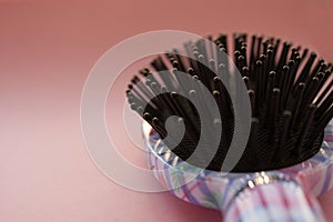 Hair massage comb brush with handle for all types  on pink pastel copy space background. Minimalistic style.