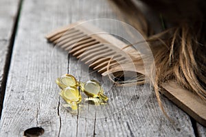 Hair nurishment. vitamin serum capsule on wooden background