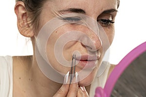 Hair over the upper lip in women. girl with tweezers plucks a mustache. female antennae. problem skin