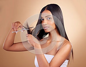 Hair, portrait and Indian woman with scissors in studio for self haircut or trim on brown background. Haircare, face and