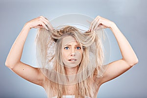 Hair, portrait and woman in studio for hair care, problem and fail or hair loss against grey background. Confused, girl