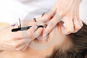 Hair removal. Adjusting the eyebrows in the beauty salon. photo