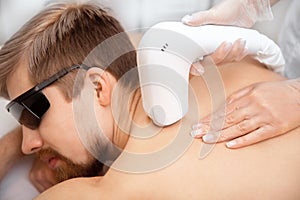 Hair removal cosmetology procedure from men back laser epilation studio, top view
