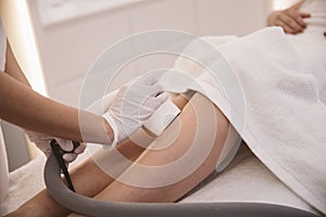 Hair removal cosmetology procedure from a therapist at cosmetic clinic.
