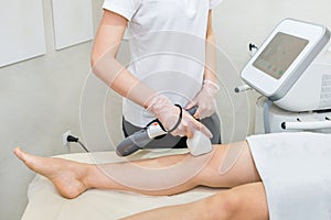 Hair removal on the legs, laser procedure at medical clinic