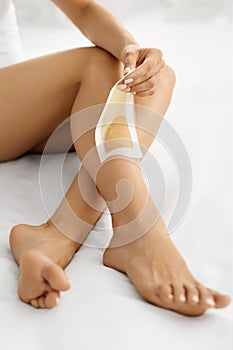 Hair Removal. Long Woman Legs With Wax Strip On. Depilation