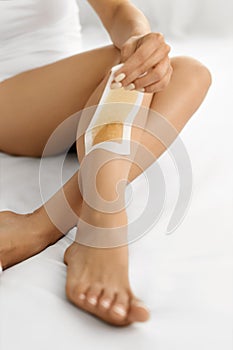Hair Removal. Long Woman Legs With Wax Strip On. Depilation