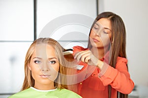 Hair salon. Womens haircut. Use of straightener. photo