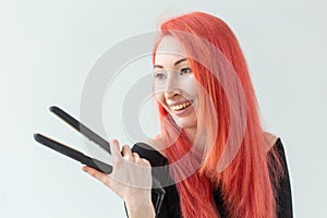 Hair style, hairdresser and people concept - stylish red-haired woman with curling iron on white background.