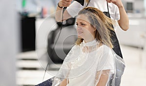 Hair styling process in beauty salon with hair dryer