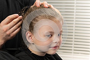 Hair stylist fixes with a hairpin hairstyle for a girl photo