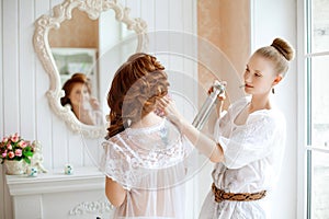 Hair stylist makes the bride on the wedding day