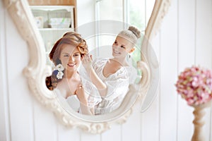 Hair stylist makes the bride before the wedding