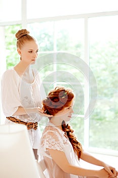 Hair stylist makes the bride on the wedding day