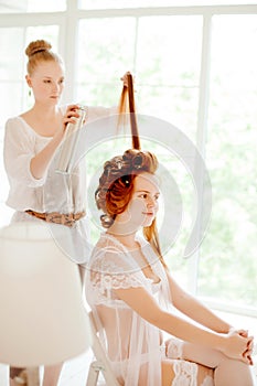 Hair stylist makes the bride on the wedding day