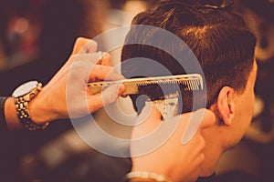 Hair stylist using comb and razor