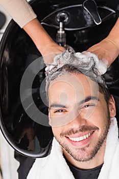 Hair stylist washing mans hair