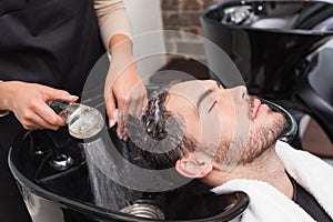 Hair stylist washing mans hair