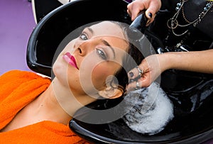 Hair stylist washing woman head