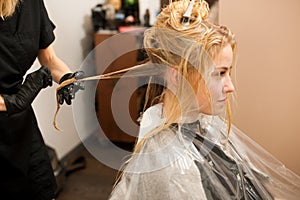 Hair stylist at work - hairdresser applying a color on custom