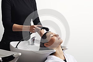 Hair treatment in salon, hairdresser washing client`s hair