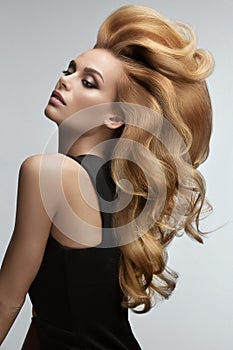 Hair volume. Portrait of beautiful Blonde with Long Wavy Hair.