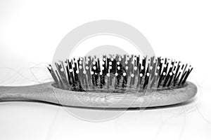 Hairbrush close-up with hair in the teeth of a comb