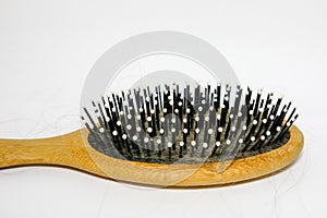 Hairbrush close-up with hair in the teeth of a comb