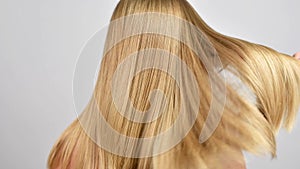 Haircare. Beautiful healthy straight hair. Woman moves blonde long hair