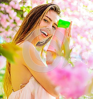 Haircare. Smiling woman with shampoo or conditioner. Beauty product. Beautiful girl with bottle of shampoo. Balm bottle