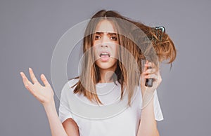 Haircare. Straightening woman with straight brushed hair. Hair tangling problem. Unhappy girl with tangled hair. Damaged