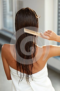 Haircare. Woman Brushing Beautiful Long Healthy Hair With Comb